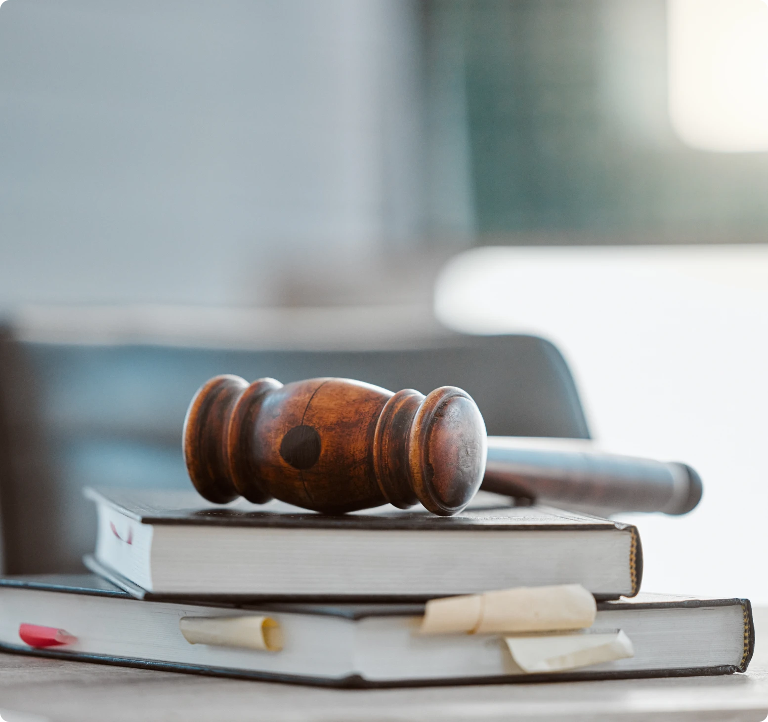 Gavel on stacked law books, blurred background.